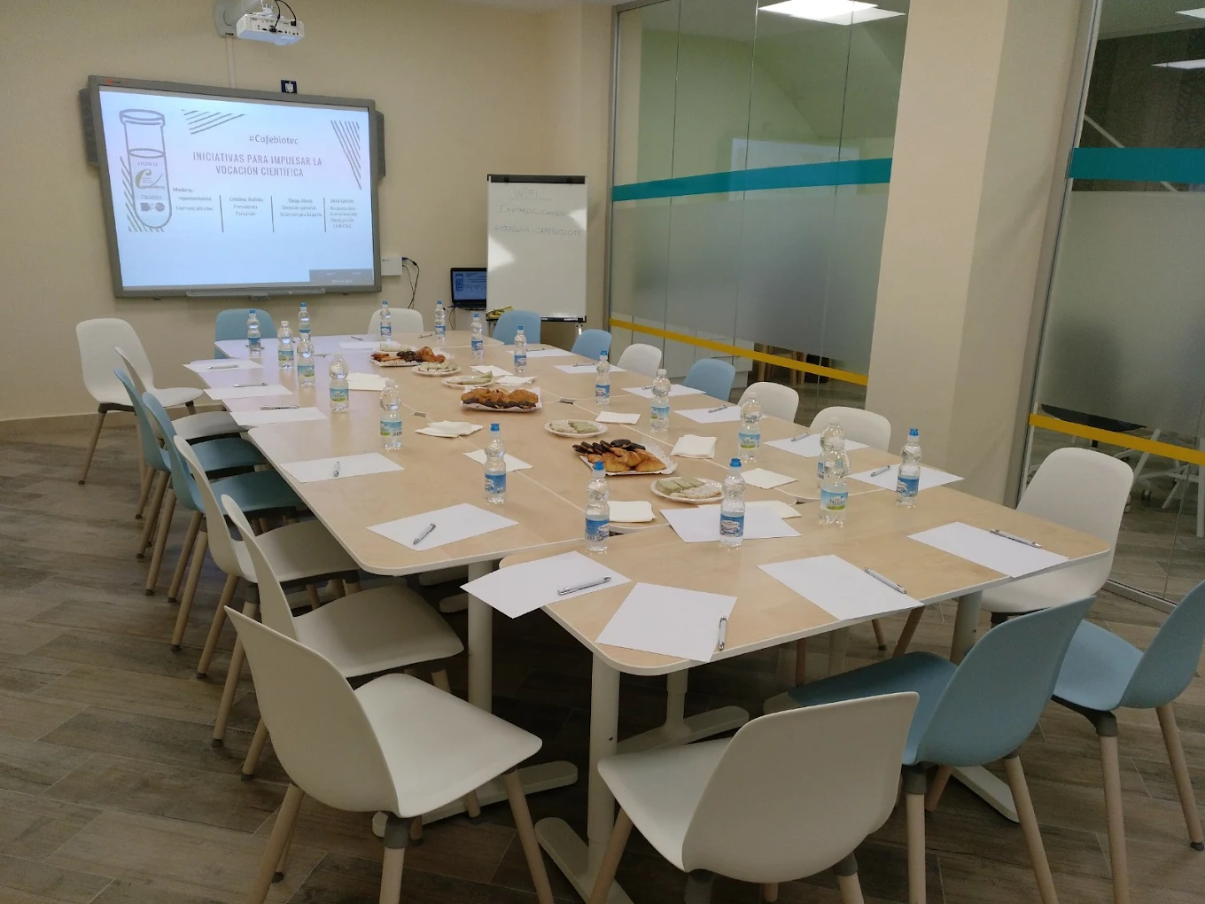 Sala de reuniones moderna en Espacio DRO Madrid, con mesa amplia, sillas, proyector, pantalla y material preparado para formación, ideal para cursos, eventos corporativos y reuniones profesionales en un entorno equipado y funcional.